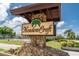 Community sign featuring a palm tree and the community name, Meadowcroft at 5709 13Th W Ave, Bradenton, FL 34209