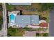 Aerial view of a home with pool, spa, brick driveway, and manicured landscaping in a fenced yard at 580 Russell St, Longboat Key, FL 34228