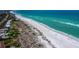 Breathtaking aerial view of a beautiful sandy beach bordering sparkling turquoise ocean waters at 580 Russell St, Longboat Key, FL 34228