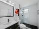 Contemporary bathroom featuring a vanity with black fixtures, a shower with glass, and accent art at 580 Russell St, Longboat Key, FL 34228