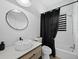 Modern bathroom with a sleek sink, wooden vanity, and a shower-tub combo at 580 Russell St, Longboat Key, FL 34228