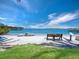 Inviting beach view with boats, seating, white sand, and clear blue waters under a sunny sky at 580 Russell St, Longboat Key, FL 34228