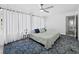 Inviting bedroom with a ceiling fan, patterned blue rug, and natural light from white-curtained windows at 580 Russell St, Longboat Key, FL 34228