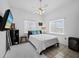 Serene bedroom features a ceiling fan, bright windows with shades, and minimalist decor at 580 Russell St, Longboat Key, FL 34228