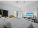 Bright bedroom with a comfortable bed, balcony access, and a sleek entertainment center at 580 Russell St, Longboat Key, FL 34228