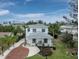 A beautifully landscaped front yard leads up to this lovely two-story home with eye-catching gray roof and white siding at 580 Russell St, Longboat Key, FL 34228
