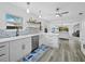 Bright modern kitchen with white cabinets, an island with seating, and seamless flow to living area at 580 Russell St, Longboat Key, FL 34228