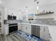 A modern kitchen featuring stainless appliances, white cabinetry, tile backsplash, and ample counter space at 580 Russell St, Longboat Key, FL 34228