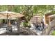 Lush outdoor dining area with mature trees, string lights, and umbrella-covered tables and chairs on a bright day at 580 Russell St, Longboat Key, FL 34228
