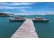 Picturesque view of a wooden pier leading into turquoise water, with boats docked in the distance at 580 Russell St, Longboat Key, FL 34228