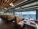 Charming restaurant interior with wooden booths, tables, and a scenic waterfront view of the bay at 580 Russell St, Longboat Key, FL 34228