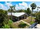 Backyard view of home, showcasing outdoor seating, lush landscaping, and inviting atmosphere, with waterfront access at 602 Baronet Ln, Holmes Beach, FL 34217
