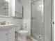 Well-lit bathroom featuring a glass enclosed shower and white vanity at 602 Baronet Ln, Holmes Beach, FL 34217