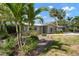 Charming single-story home with a well-maintained lawn and lush tropical landscaping in a serene setting at 602 Baronet Ln, Holmes Beach, FL 34217