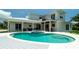 Exterior of home showcasing a backyard with a pool, spa, patio, and well-manicured lawn at 603 Emerald Ln, Holmes Beach, FL 34217