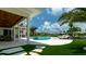 Expansive backyard with a beautiful pool, spa, outdoor seating, and lush landscaping at 603 Emerald Ln, Holmes Beach, FL 34217