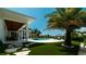 Spacious backyard with pool, patio, manicured synthetic grass, and tropical landscaping at 603 Emerald Ln, Holmes Beach, FL 34217