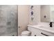 Bright bathroom features white vanity with black hardware and a glass-enclosed shower with marble-look tile surround at 603 Emerald Ln, Holmes Beach, FL 34217