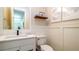 This half bathroom features decorative wall trim, floating wood shelf and a white vanity with dark hardware at 603 Emerald Ln, Holmes Beach, FL 34217