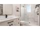 Elegant bathroom features a white vanity with dark fixtures and a marble-tiled shower with glass door at 603 Emerald Ln, Holmes Beach, FL 34217