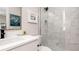Stylish bathroom with a white vanity, framed art, and a frameless glass shower with marble tile at 603 Emerald Ln, Holmes Beach, FL 34217