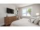 Inviting bedroom with hardwood floors, a decorative dresser and a light-filled window showcasing a palm tree at 603 Emerald Ln, Holmes Beach, FL 34217