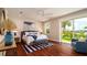 This primary bedroom features a wicker bed frame, wooden floors, and natural light from sliding glass doors at 603 Emerald Ln, Holmes Beach, FL 34217