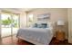 Airy bedroom with a plush bed, nautical decor, and sliding door with access to the pool area at 603 Emerald Ln, Holmes Beach, FL 34217