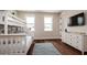 Bright bedroom with white bunk beds, hardwood floors, and a white dresser with a television at 603 Emerald Ln, Holmes Beach, FL 34217