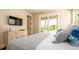 Bright primary bedroom featuring a plush bed, modern accents, and a sliding door with pool views at 603 Emerald Ln, Holmes Beach, FL 34217