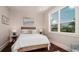 Cozy bedroom with wood floors, wicker headboard, and a large window offering bright, natural light at 603 Emerald Ln, Holmes Beach, FL 34217