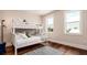 Charming bedroom with a white bunk bed, hardwood floors, and natural light from the two windows at 603 Emerald Ln, Holmes Beach, FL 34217