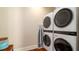 This laundry area features stacked front-load machines, dark floors, and an ironing board for convenience at 603 Emerald Ln, Holmes Beach, FL 34217