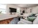 Cozy living room featuring a large television, comfortable sectional sofa, and hardwood floors at 603 Emerald Ln, Holmes Beach, FL 34217