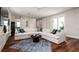 Open-concept living room features a large sectional sofa, stylish rug, and wood flooring at 603 Emerald Ln, Holmes Beach, FL 34217