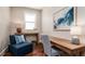 Cozy office space features a wood desk, blue chair, and soft natural light from a window at 603 Emerald Ln, Holmes Beach, FL 34217