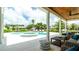 Relaxing covered patio with comfortable seating area overlooking the pool and lush tropical backyard at 603 Emerald Ln, Holmes Beach, FL 34217