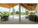 Inviting outdoor patio featuring a dining area and wicker furniture overlooking the pool and waterfront at 603 Emerald Ln, Holmes Beach, FL 34217