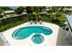Aerial view of pool and spa area with lounge chairs and tropical landscaping overlooking the waterfront canal at 603 Emerald Ln, Holmes Beach, FL 34217