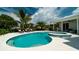 Beautiful pool and spa featuring a light-colored patio area, surrounded by palms and lush landscaping at 603 Emerald Ln, Holmes Beach, FL 34217