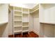 Walk-in closet with white shelving units, wooden floors, and hanging rods for optimal storage and organization at 603 Emerald Ln, Holmes Beach, FL 34217