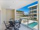 Inviting condo balcony features an outdoor dining set and overlooks the community pool and nearby buildings at 6512 Midnight Pass Rd # 303, Sarasota, FL 34242