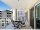 Relaxing covered balcony with outdoor seating and views of nearby buildings and blue skies at 6512 Midnight Pass Rd # 303, Sarasota, FL 34242
