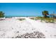 Inviting beach with sugar-white sand, turquoise water, and swaying palm trees at 6512 Midnight Pass Rd # 303, Sarasota, FL 34242