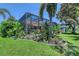 Backyard view with screened in pool and lush tropical landscaping at 6539 Flycatcher Ln, Lakewood Ranch, FL 34202