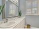 Bright bathroom featuring double sinks with a large mirror, shuttered windows for natural light, and a clean, modern design at 6539 Flycatcher Ln, Lakewood Ranch, FL 34202