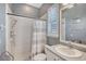 This well-lit bathroom includes a shower, toilet, sink, and shuttered window, providing essential amenities in a compact design at 6539 Flycatcher Ln, Lakewood Ranch, FL 34202