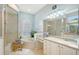 Bright bathroom featuring a soaking tub under a shuttered window, a glass shower, and double sinks with ample counter space at 6539 Flycatcher Ln, Lakewood Ranch, FL 34202