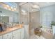 Beautiful bathroom with a soaking tub, glass-enclosed shower, double sinks, and shuttered windows for natural light and privacy at 6539 Flycatcher Ln, Lakewood Ranch, FL 34202