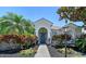 Inviting home entrance showcasing a blue front door, lovely landscaping, and rocking chairs at 6539 Flycatcher Ln, Lakewood Ranch, FL 34202